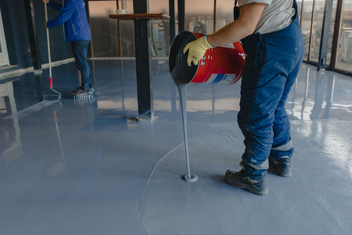 Worker-applies-grey-epoxy-paint